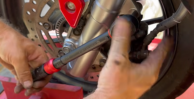 Torque wrench set to 30 Nm tightening the Honda ADV 150 rear caliper mounting bolts