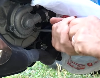 Removal of the front leg shield plastic cover to access the Vespa GTS coolant expansion tank