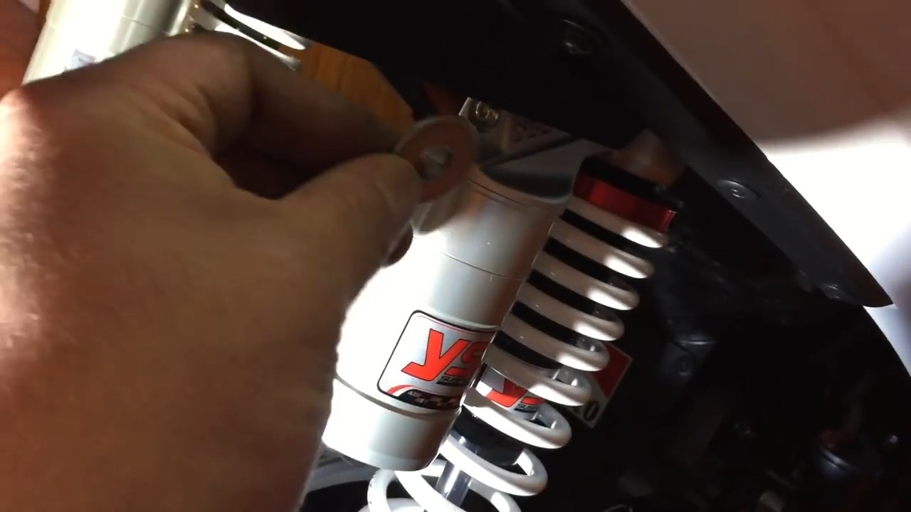 Removing the right side shock at the correct angle without forcing or stretching surrounding components on the Yamaha NMAX