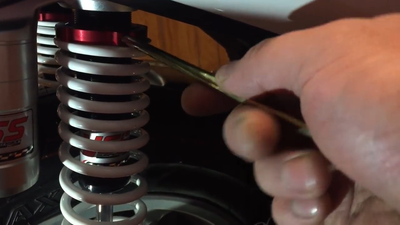Using the YSS adjustment tool to rotate the preload collar after releasing the locking screw on the Yamaha NMAX rear shock
